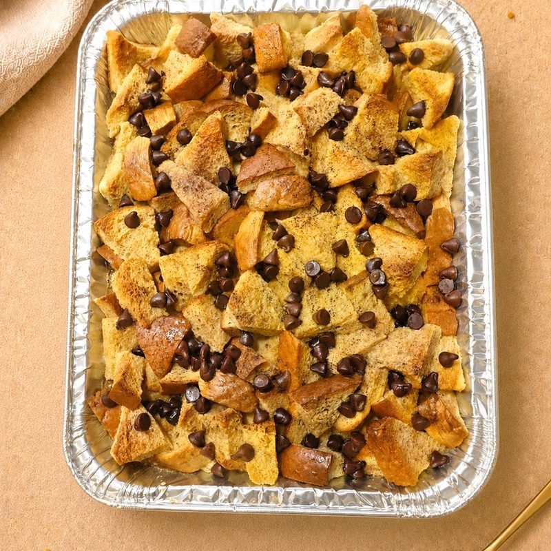 Tray of brioche bread and butter pudding studded with chocolate chips