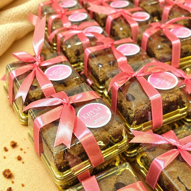 Rows of brookies party favour boxes tied with pink ribbon and a KRYM Delights sticker