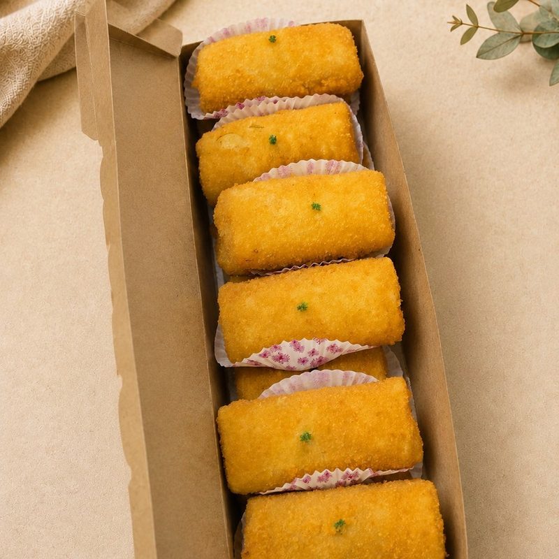 Crispy risoles in a box, golden breadcrumb pastry rolls